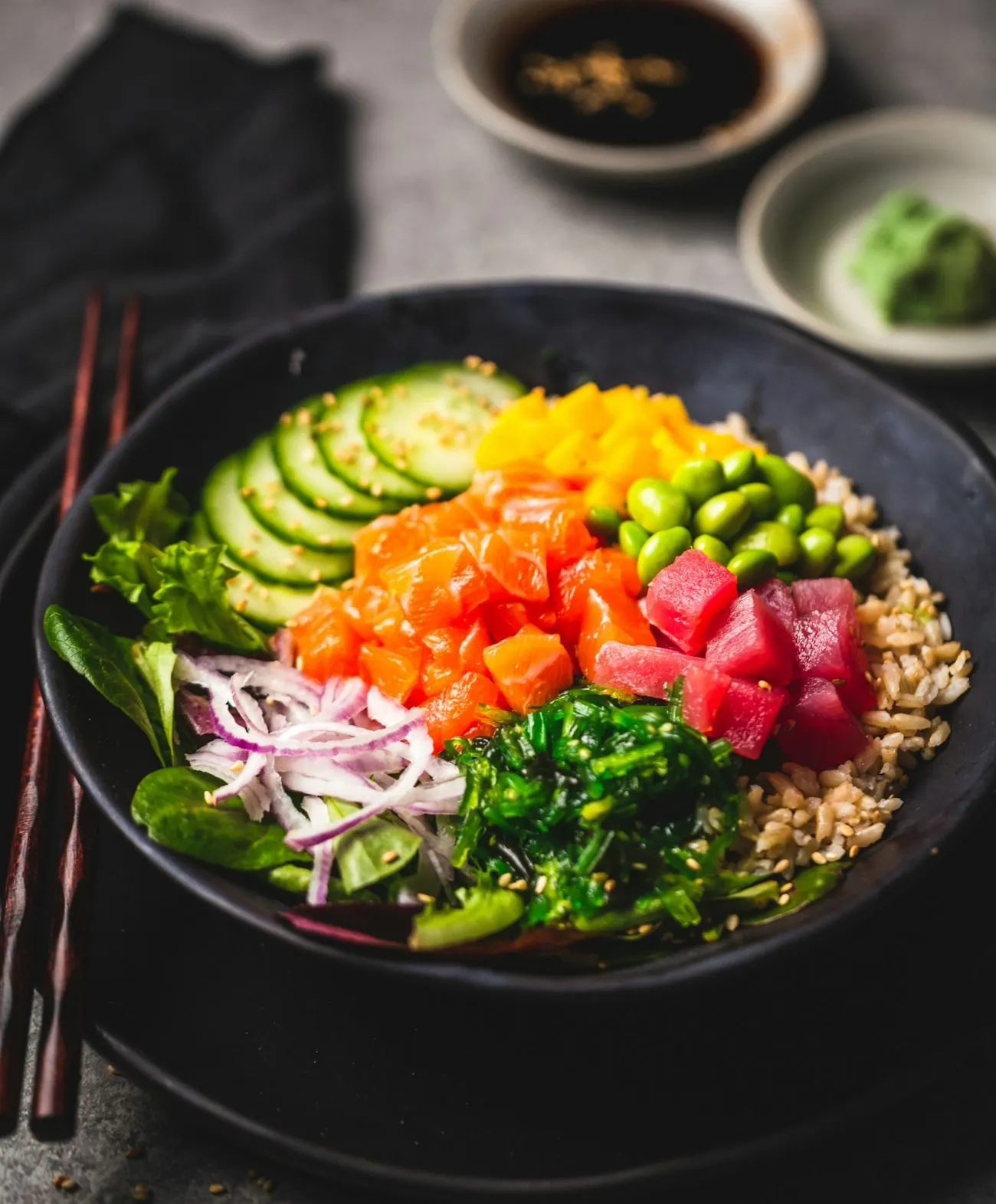 Salmon and tuna poke bowl with brown rice, edamame, mango, cucumber and seaweed